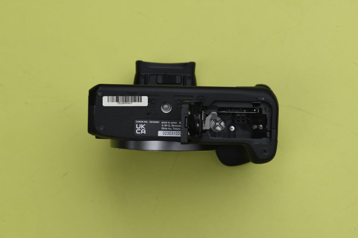 El cajón de la batería y la tarjeta SD del Canon EOS R100